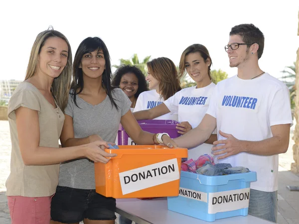 Group of volunteers collecting clothing donations — Stock Photo, Image