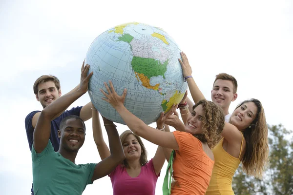 Groupe de jeunes tenant un globe terrestre Images De Stock Libres De Droits