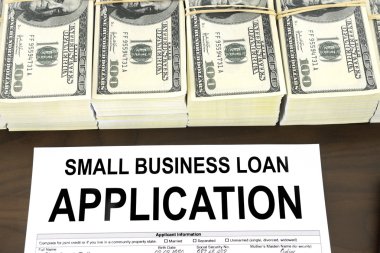 küçük işletme kredisi başvuru formu ve 100 dolar faturaları yığınları onaylı