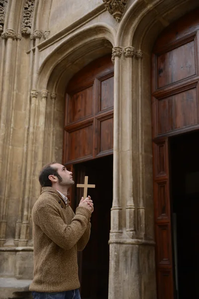 Člověk se modlí v kostele drží růženec — Stock fotografie