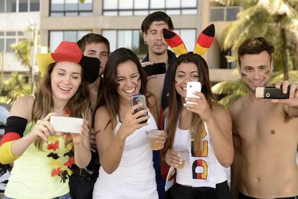 Fãs de futebol alemão segurando smartphones — Fotografia de Stock