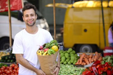 meyve ve sebze dolu bir alışveriş kağıt torba taşıyan adam