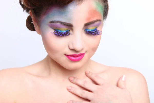 Mujer hermosa con cosméticos creativos coloridos — Foto de Stock