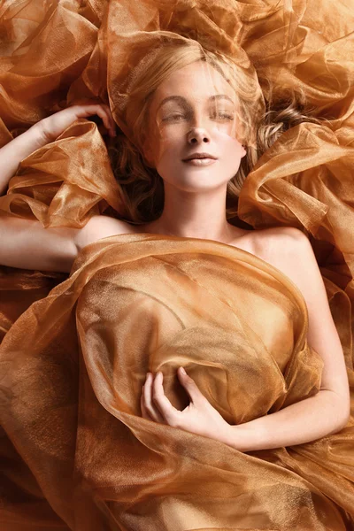 Vrouw gewikkeld in koper stroomt stof — Stockfoto