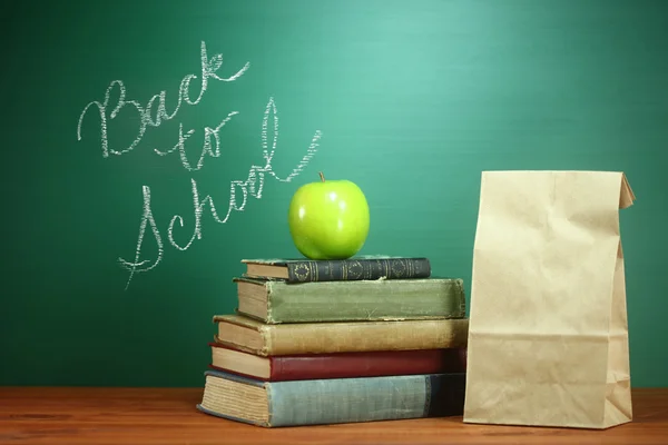 Bücher, Apfel und Mittagessen auf dem Lehrertisch — Stockfoto