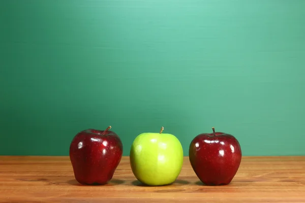 Skolan äpplen sitter på lärare skrivbord i rad — Stockfoto