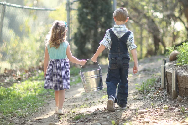 Niños trabajando en la granja con un cubo — Foto de Stock