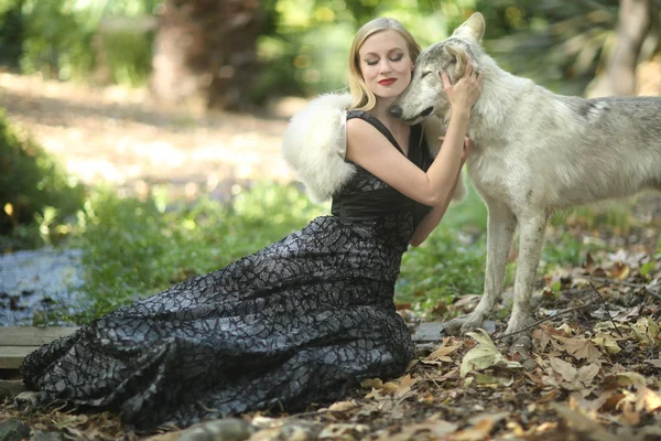 Härlig kvinna poserar med en varg — Stockfoto