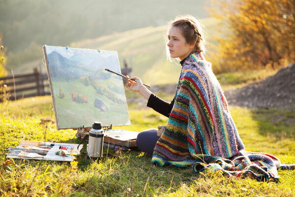 Молодой художник рисует пейзаж
