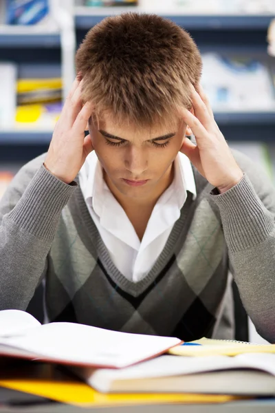 Beau garçon étudiant dans une bibliothèque — Photo