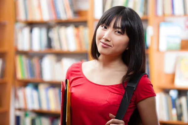 Mooie vrouwelijke student in een bibliotheek — Stockfoto