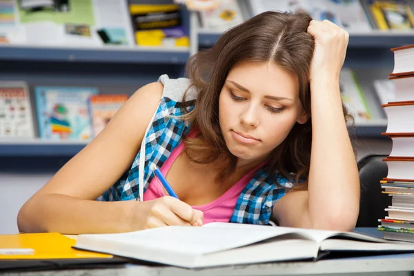 Hermosa estudiante en una biblioteca — Foto de Stock