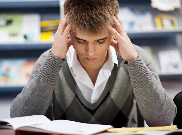 Beau garçon étudiant dans une bibliothèque — Photo