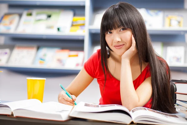 Hermosa estudiante en una biblioteca — Foto de Stock