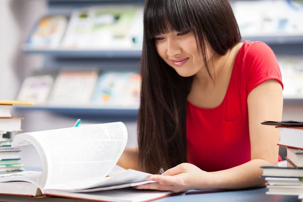 Hermosa estudiante en una biblioteca — Foto de Stock