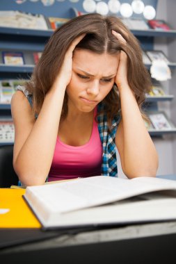 Stressed female student in a library