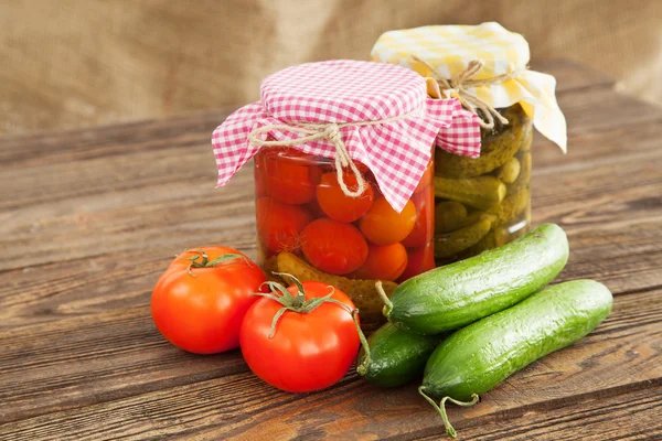 Verduras frescas y enlatadas sobre una mesa de madera — Foto de Stock