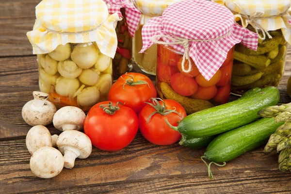 Verduras frescas y enlatadas sobre una mesa de madera — Foto de Stock