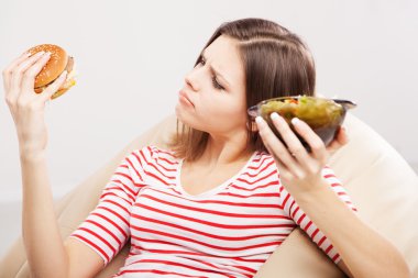 ince kadın bir salata ve hamburger arasında seçim yapma