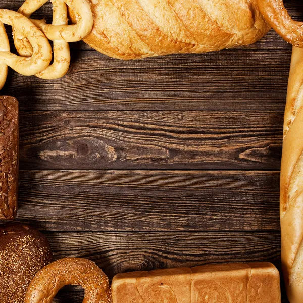 Ассортимент хлеба на деревянном столе — стоковое фото