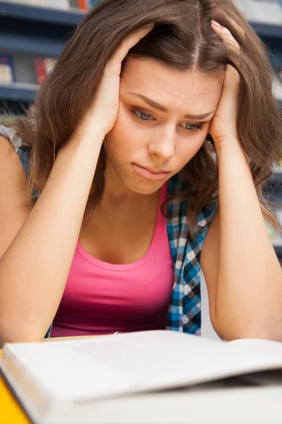 Estudante feminina estressada em uma biblioteca universitária — Fotografia de Stock
