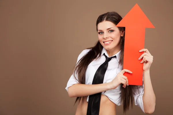 Mulher em um traje de estudante segurando um sinal de seta — Fotografia de Stock