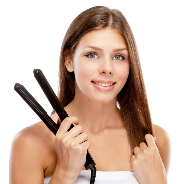 Jonge vrouw met een hair straightener — Stockfoto