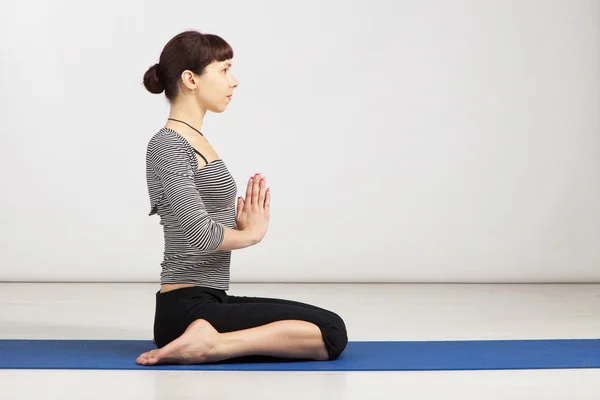 Ung kvinna utövar yoga — Stockfoto