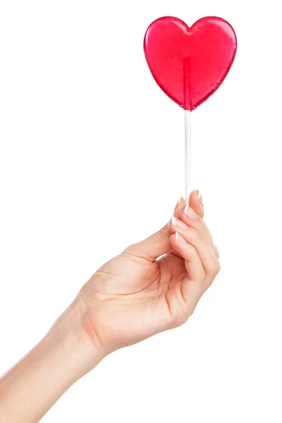 Female hand holding a heart-shaped lollipop — Stock Photo, Image