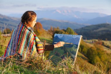 Genç ressam sonbahar manzarası çiziyor.