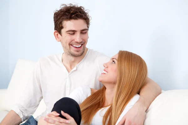 Jeune beau couple sur un canapé à la maison — Photo