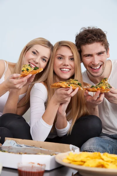 Skupina mladých lidí, jíst pizzu doma — Stock fotografie