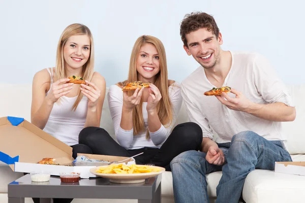 Gruppo di giovani che mangiano pizza a casa — Foto Stock