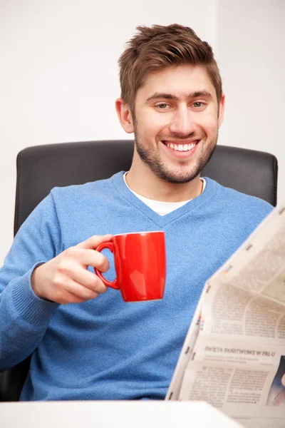 Młody człowiek czytający gazetę — Zdjęcie stockowe