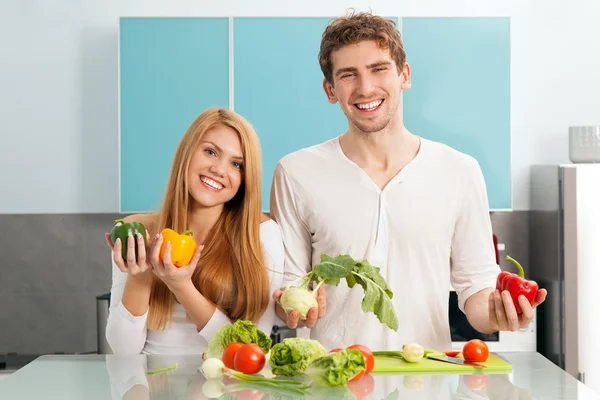 Jovem casal bonito cozinhar em casa — Fotografia de Stock