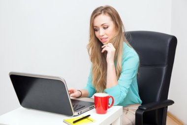 Genç sarışın bir kadın ile bir dizüstü bilgisayar çalışma