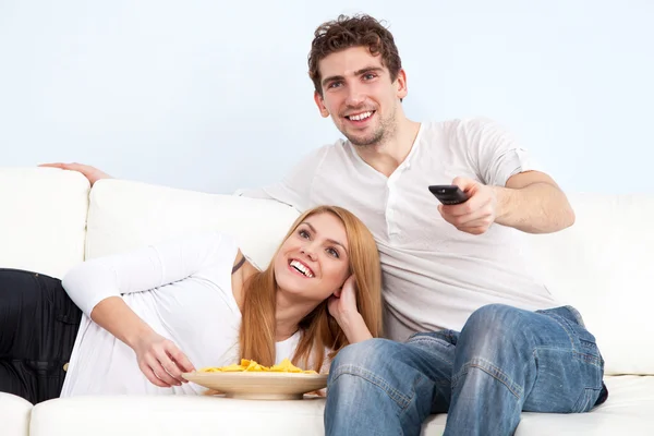 Jeune beau couple sur un canapé à la maison — Photo