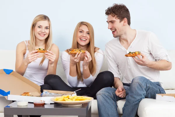 Gruppo di giovani che mangiano pizza a casa — Foto Stock