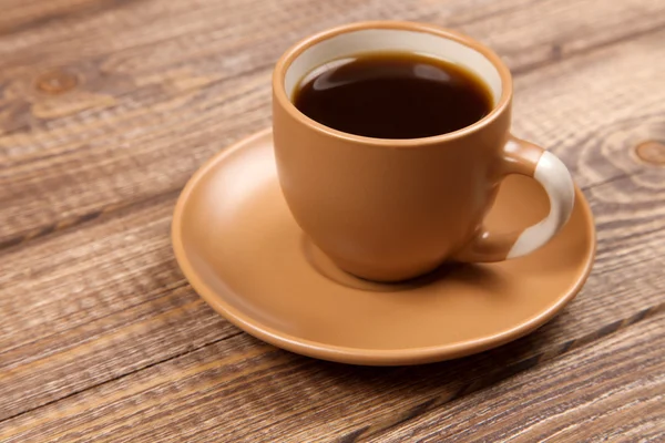 Koffiekopje op een houten tafel — Stockfoto