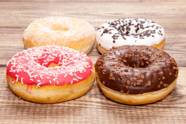 Donuts savoureux sur une table en bois — Photo