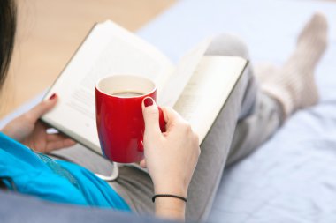 kadın yatakta kitap okuma