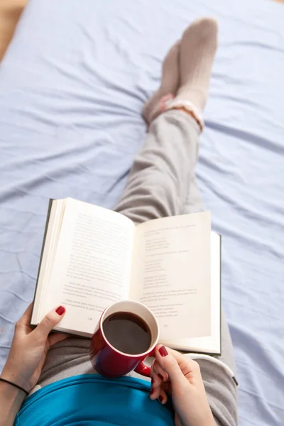 Frau liest Buch im Bett — Stockfoto