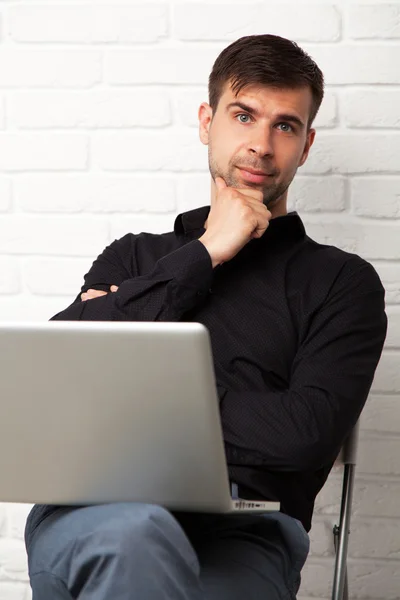 Jovem empresário com um laptop — Fotografia de Stock