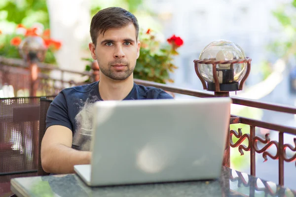 Jovem empresário com um laptop — Fotografia de Stock