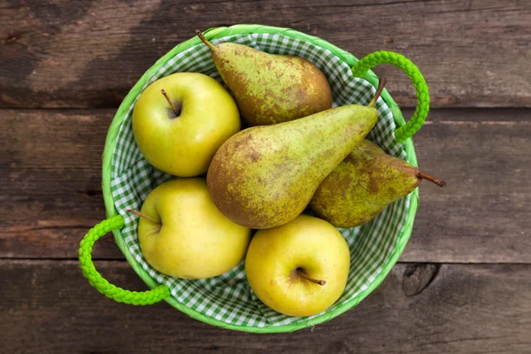 Frische grüne Äpfel und Birnen auf einem Holztisch — Stockfoto