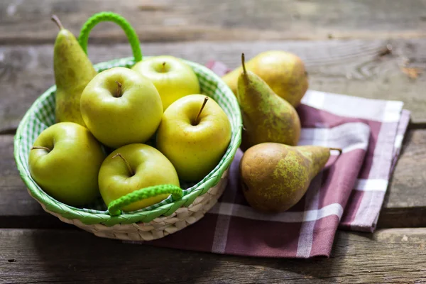 Świeże zielone jabłka i gruszki na drewnianym stołem — Zdjęcie stockowe