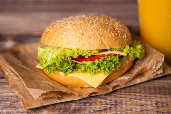 Delicious hamburger on a wooden table — Stock Photo, Image