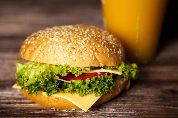 Deliciosa hamburguesa sobre una mesa de madera — Foto de Stock