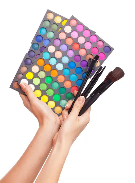Kvinnliga handen håller en makeup palett, vit bakgrund Stockfoto