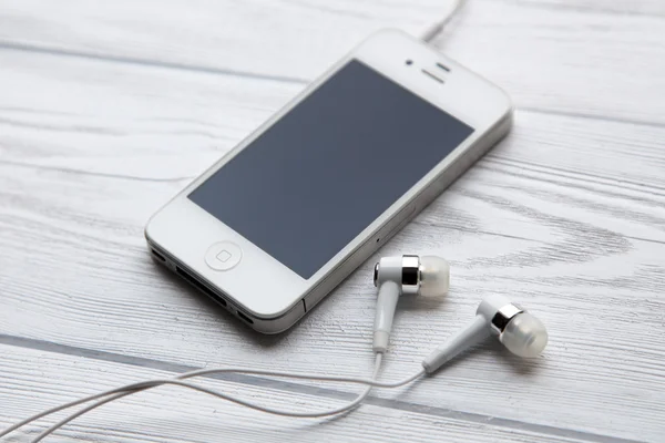 IPhone on a white wooden table — Stock Photo, Image